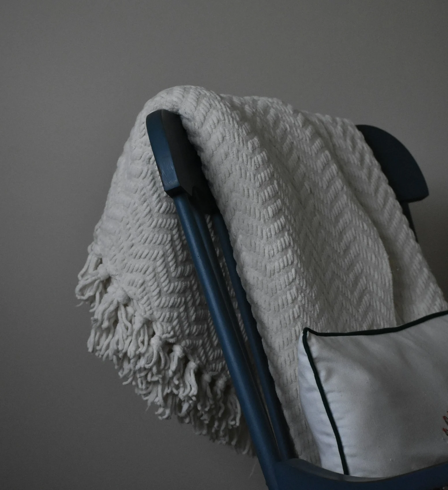 A soft, textured cream blanket draped over a chair